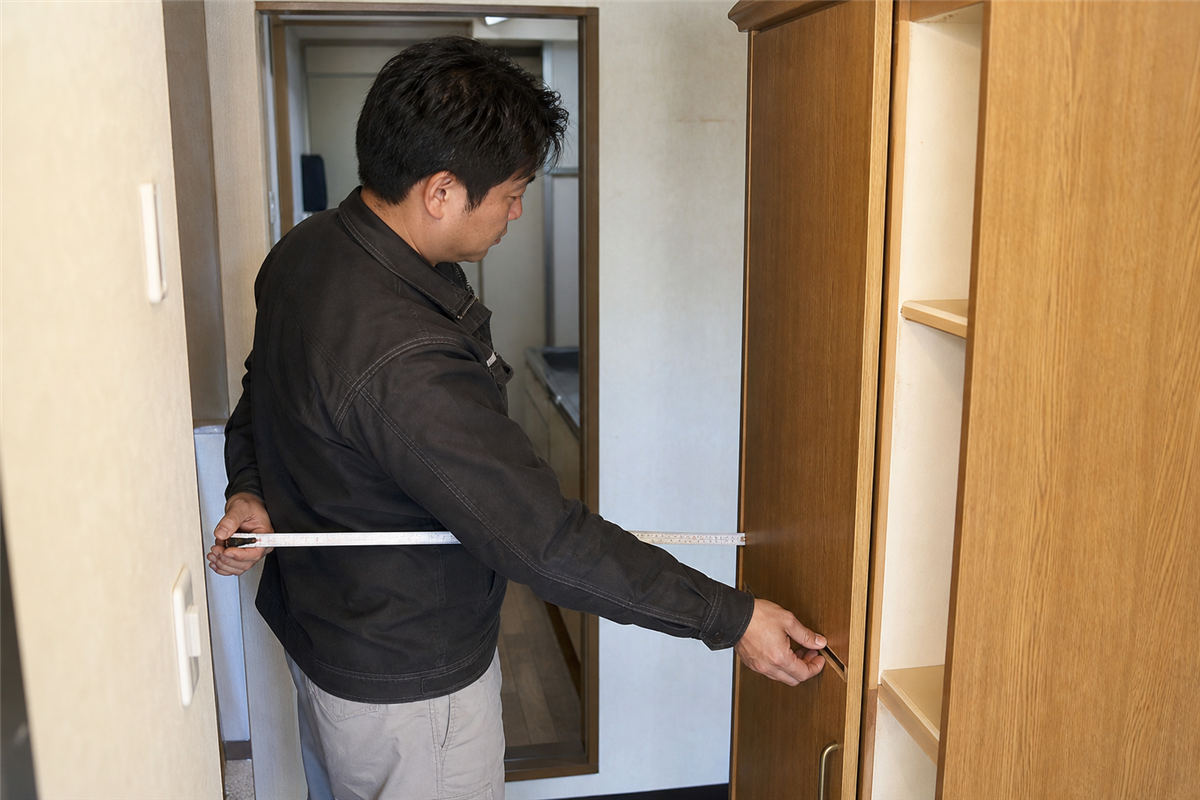 食器棚と搬出経路の寸法を測る様子