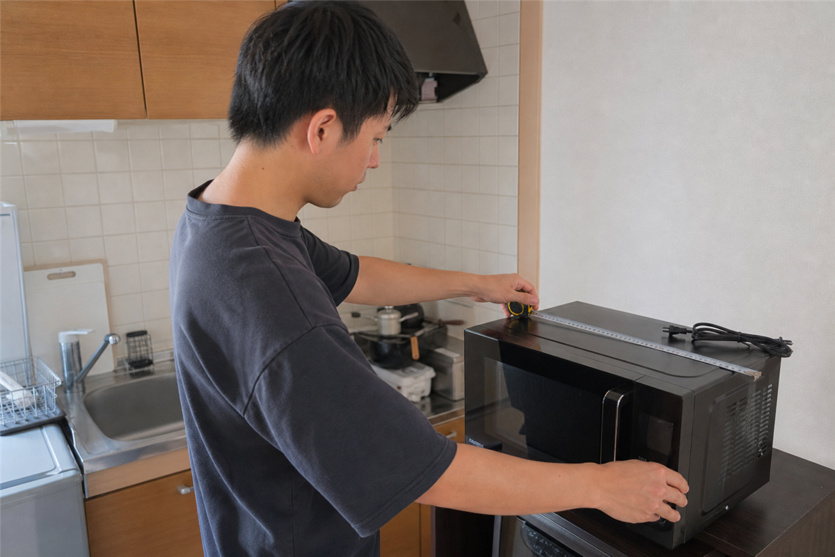 電子レンジの三辺を測る様子