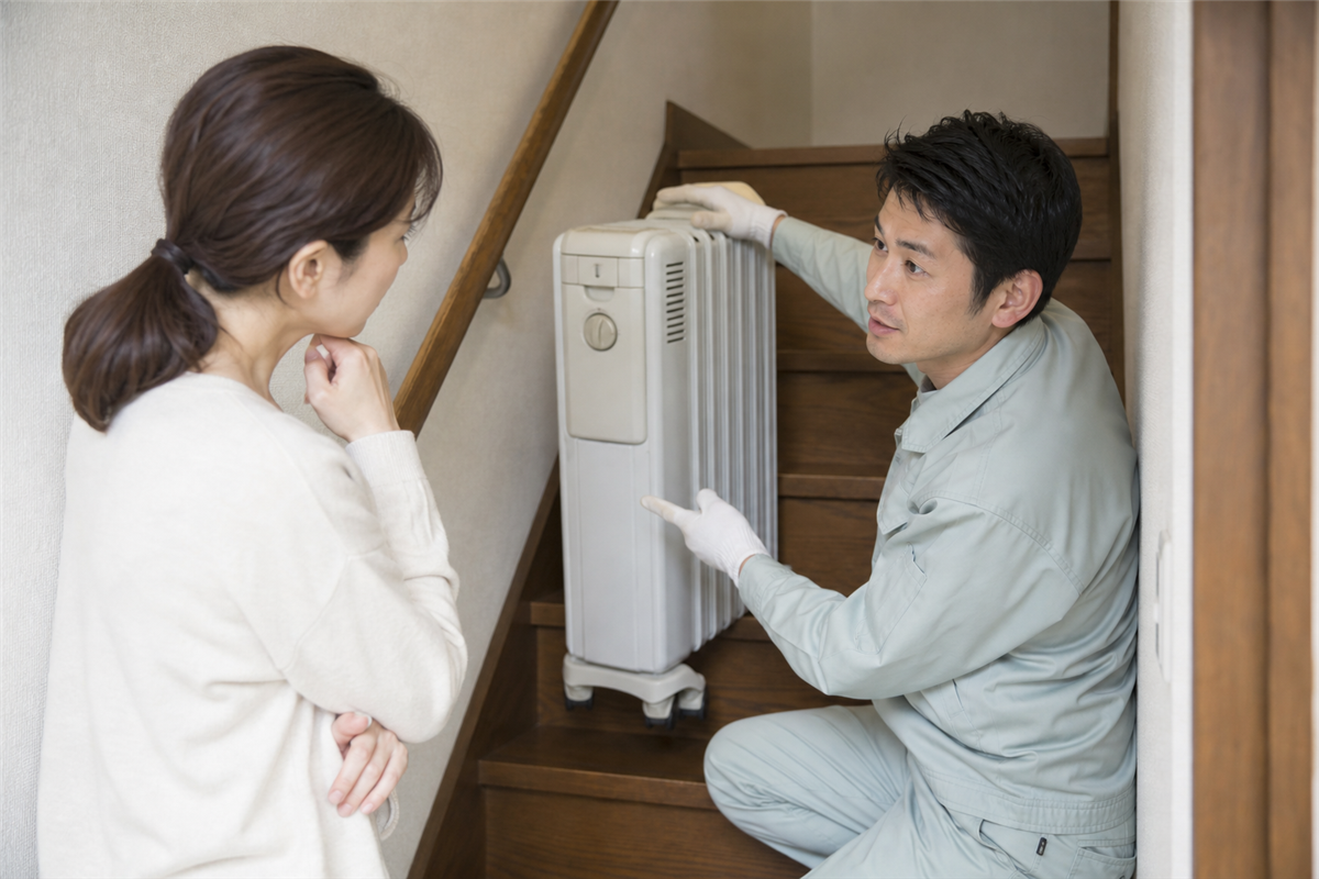 階段からの運び出し方法を相談する様子