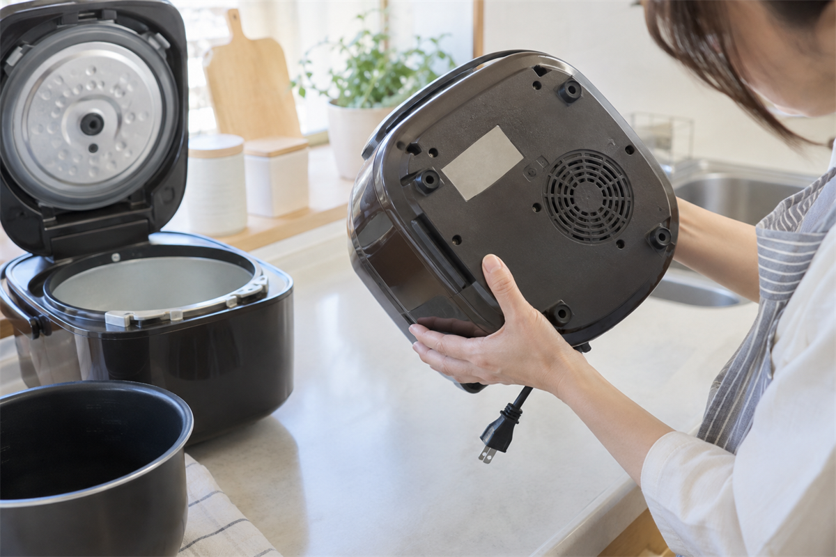 炊飯器の底面にある品番表示を確かめる手元