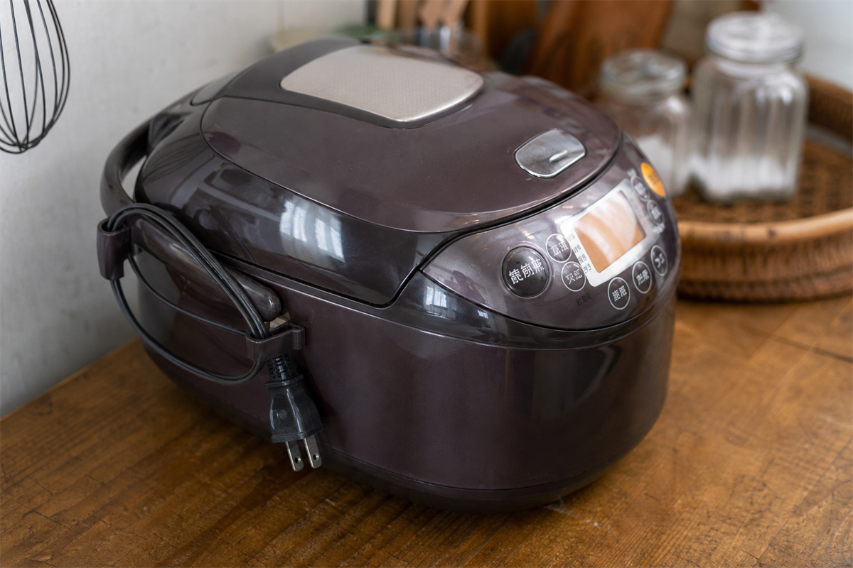 炊飯器のコードを本体側へ安全にまとめる様子